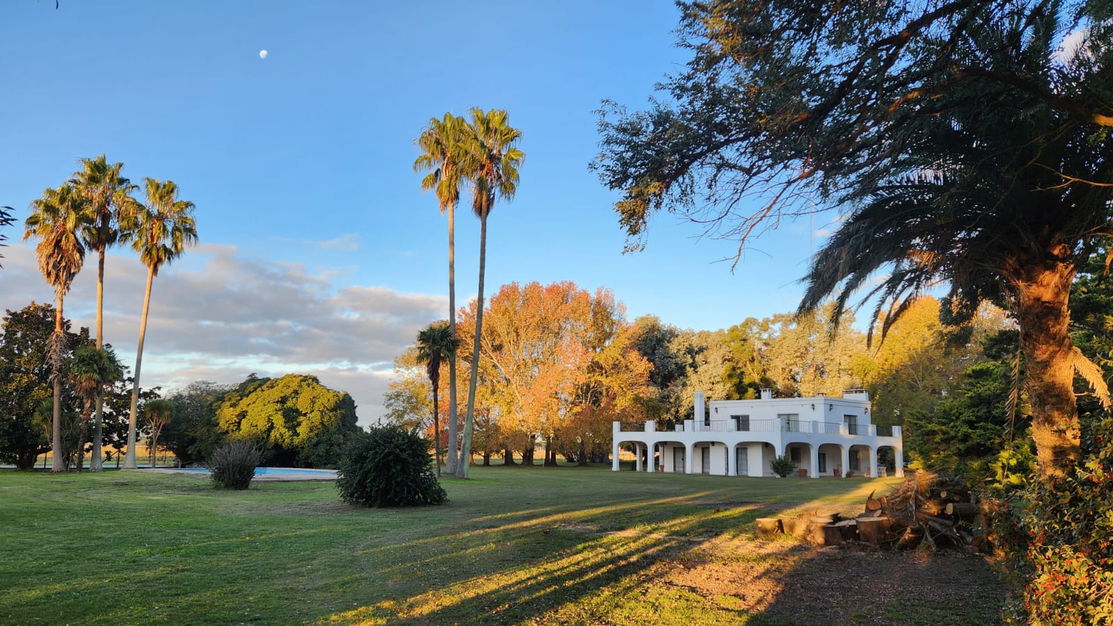 Casco de Estancia La Josefina al atardecer, entre palmeras
